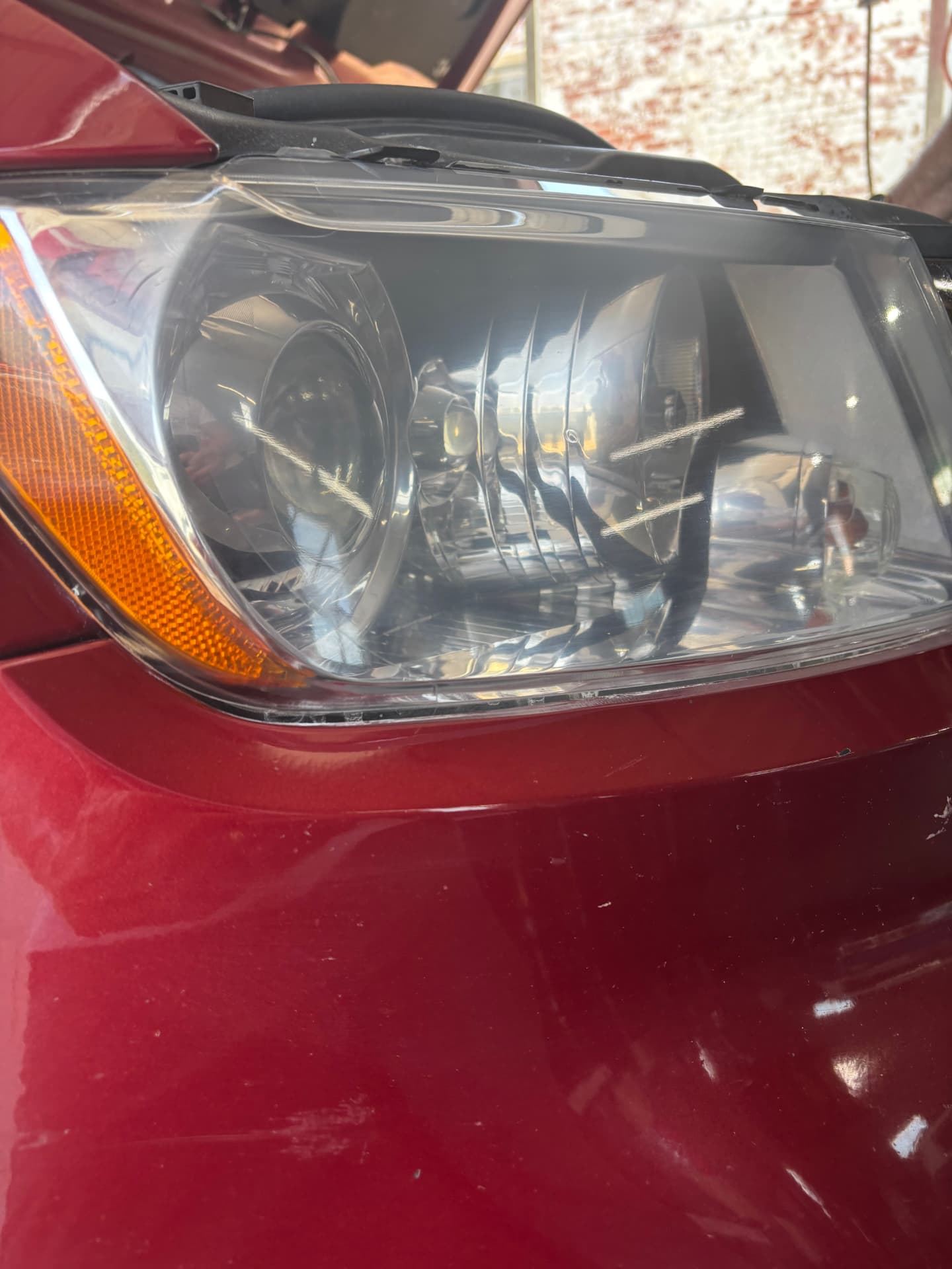 Crystal clear red sedan headlight after restoration